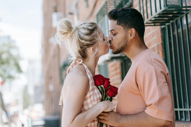 a man kissing a woman on the cheek, pexels contest winner, roses, mixed race, blonde man, sydney hanson