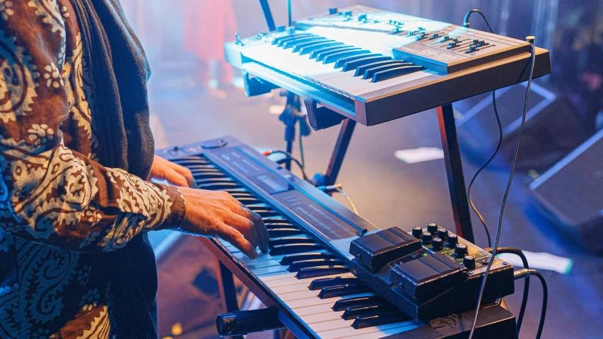 a man that is standing in front of a keyboard, by Matt Cavotta, pexels, synthetism, band playing, elaborate stage effects, mellotron, header