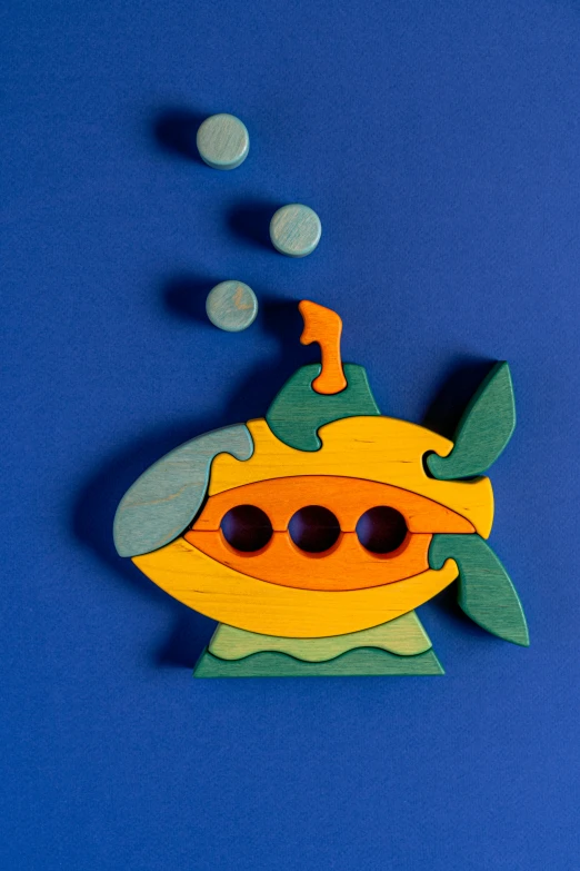 a yellow submarine sitting on top of a blue surface, a jigsaw puzzle, inspired by Alexander Milne Calder, kinetic art, thumbnail, wooden, fish, middle close up