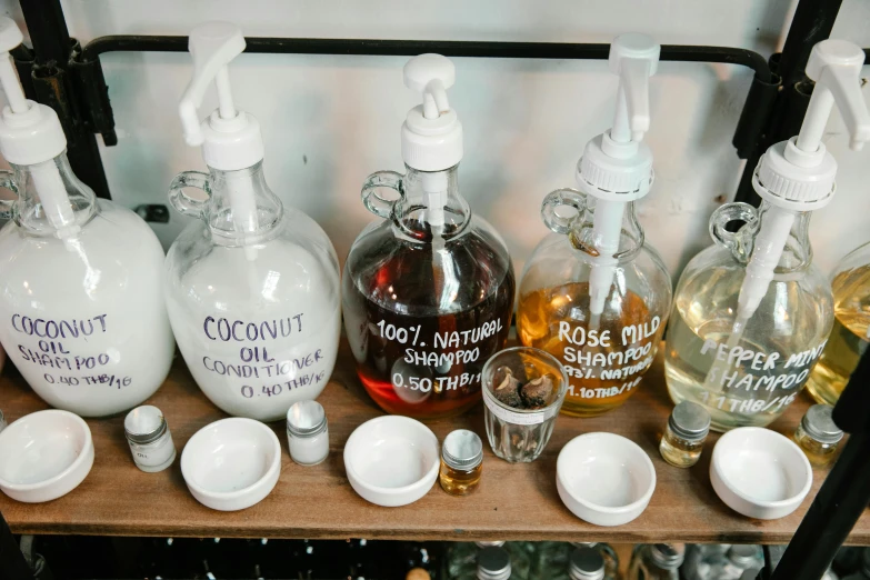 a bunch of bottles that are on a shelf, on a white table, aussie baristas, coconuts, apothecary