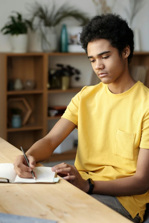 a man sitting at a table writing in a notebook, wearing yellow croptop, black teenage boy, thumbnail, multiple stories