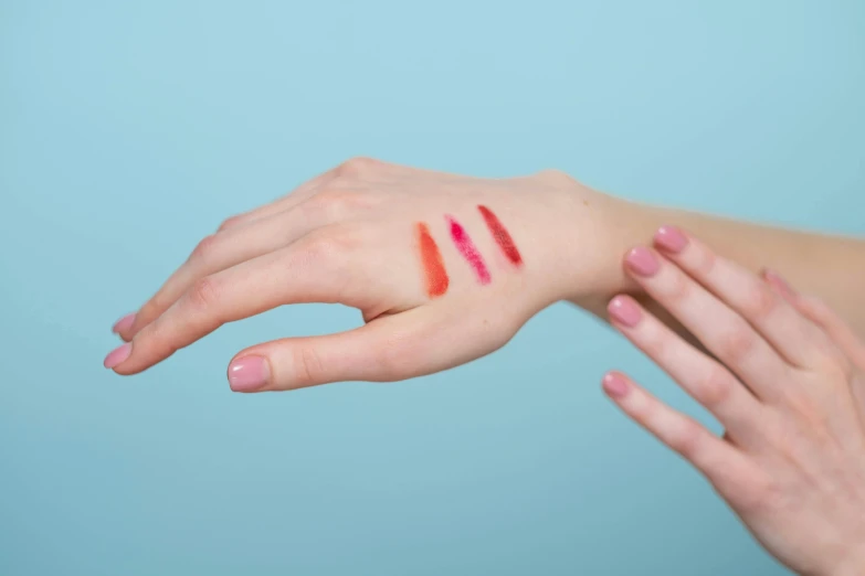 a woman's hand with three lipsticks on it, by Romain brook, synchromism, more and more scars, candy treatments, red and cyan, getty images