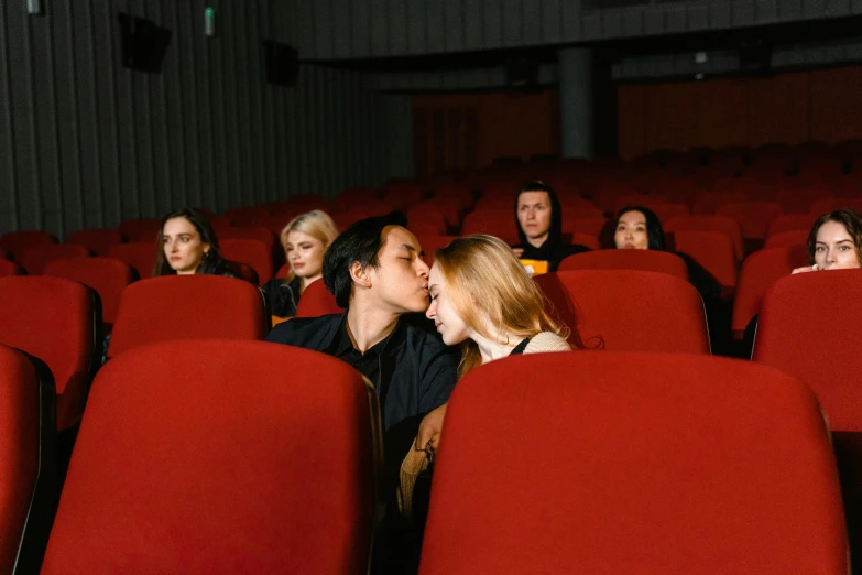 a group of people sitting in a movie theater, a picture, inspired by Nan Goldin, trending on pexels, marton gyula kiss ( kimagu ), reylo kissing, clemens ascher, couple