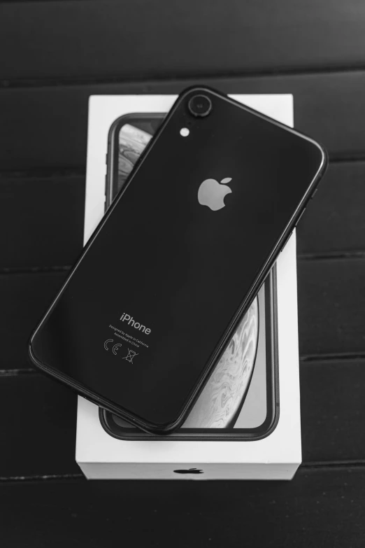 an iphone is sitting on top of a box, a picture, black and white image, 💣 💥, 2 5 6 x 2 5 6, jet - black skin