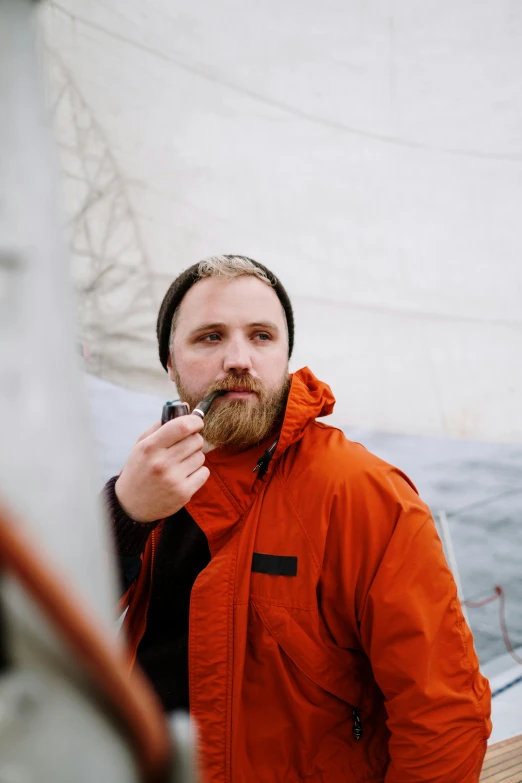 a man standing on a boat smoking a cigarette, a portrait, inspired by Jóhannes Sveinsson Kjarval, unsplash, thick braided beard, holding hot sauce, male polar explorer, eric cartman in real life
