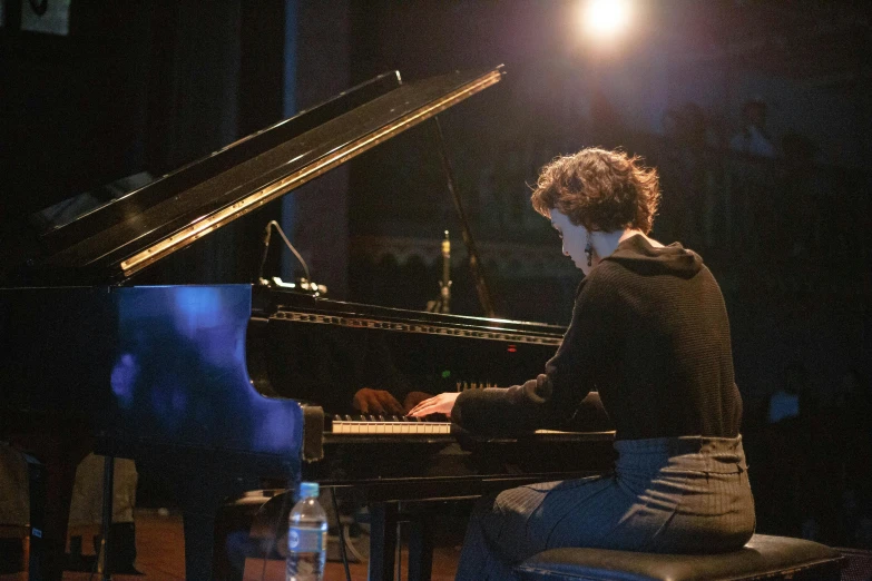 a man sitting at a piano in a dark room, by Anna Findlay, antipodeans, performing on stage, lindsay adler, promo image