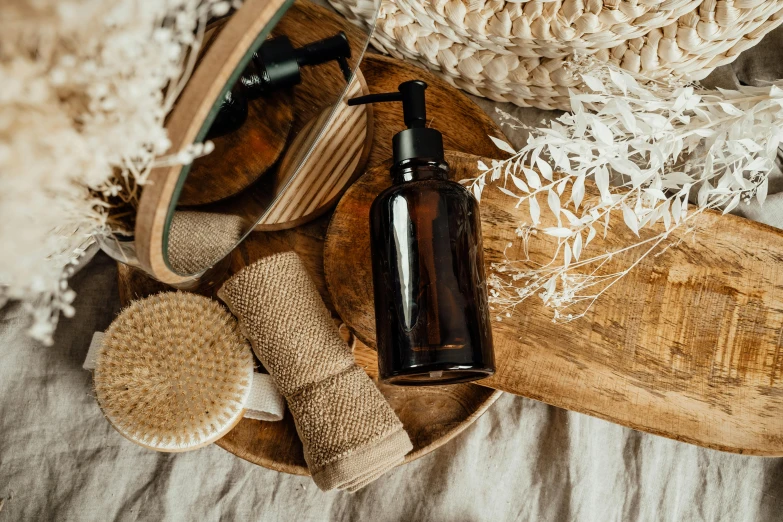 a bottle of lotion sitting on top of a wooden tray, by Julia Pishtar, pexels contest winner, natural materials, washy brush, various posed, brown