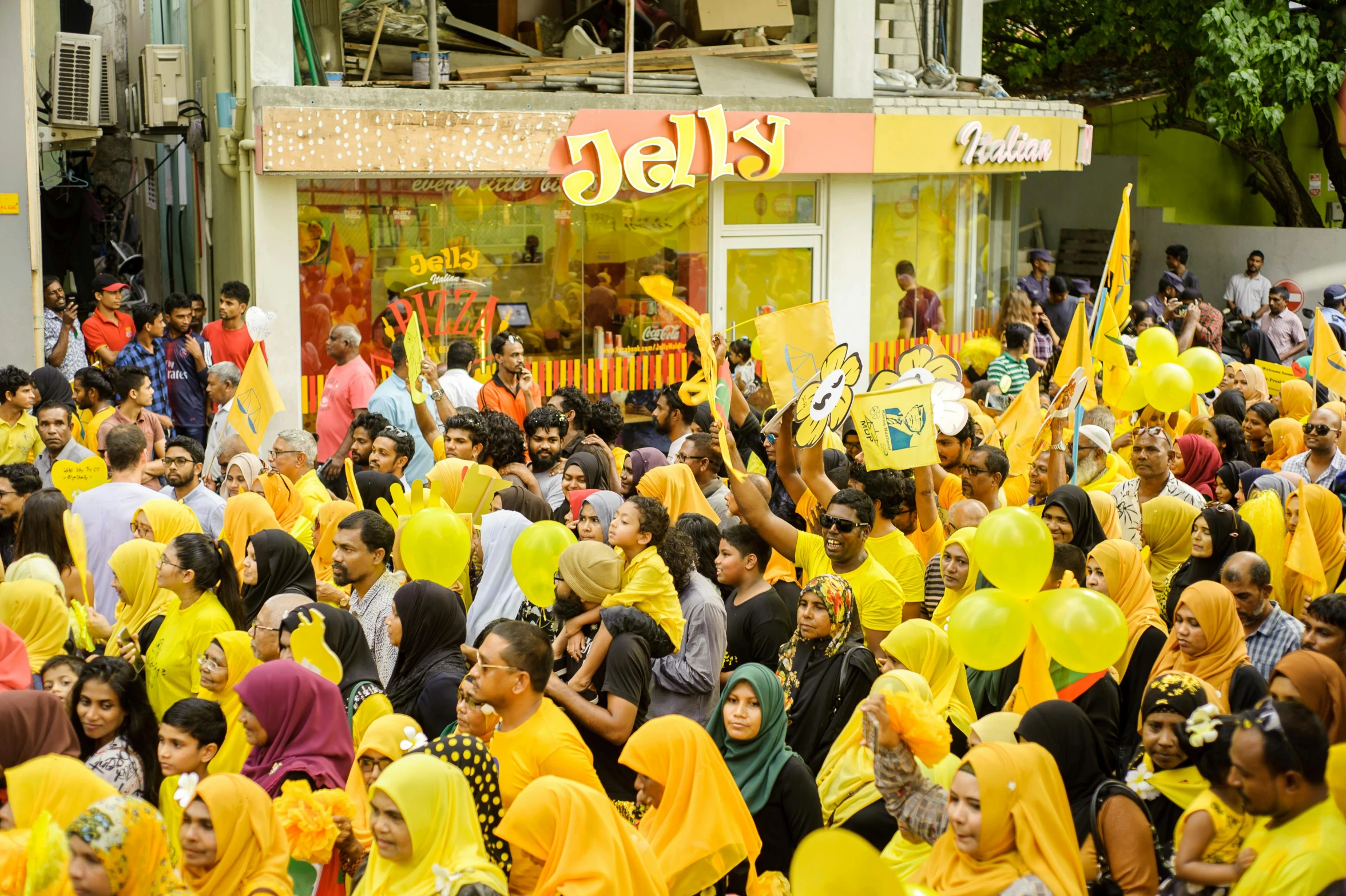 a large group of people walking down a street, hurufiyya, yellow magic theme, jello, exiting store, politics