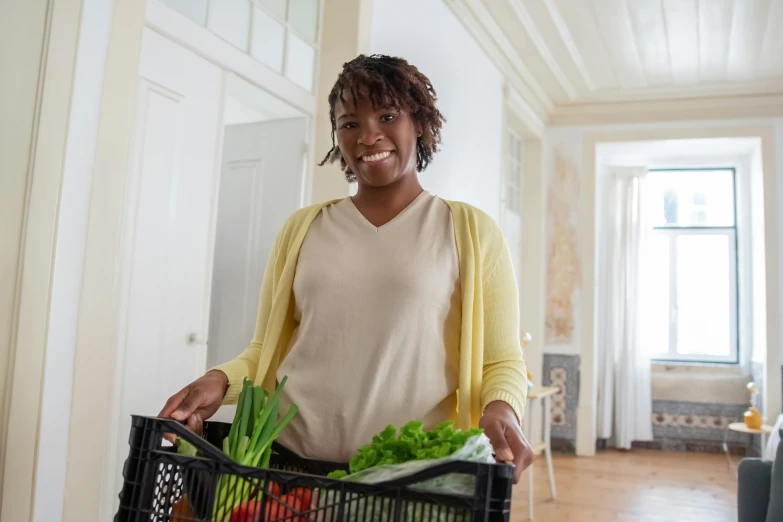 a woman holding a basket full of vegetables, happening, photo of a black woman, at home, avatar image, australian