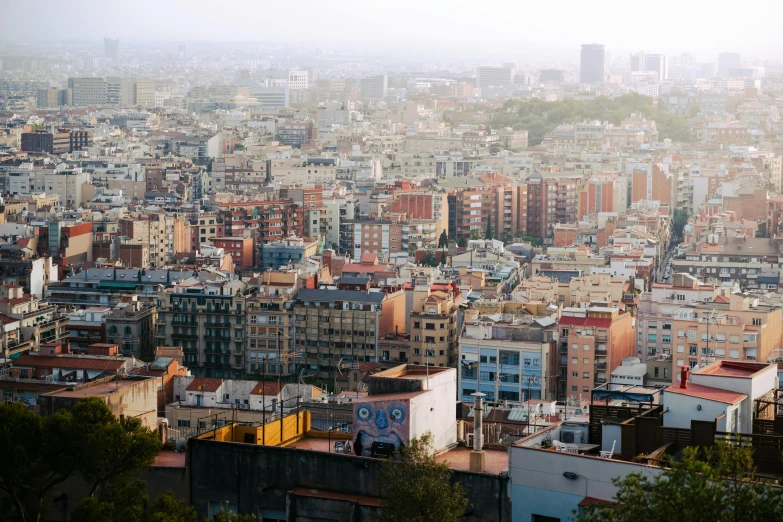a view of a city from the top of a hill, by Luis Molinari, in barcelona, fan favorite, poor buildings, joel fletcher