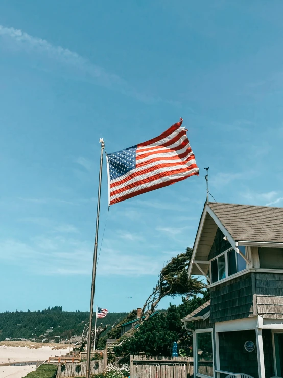 an american flag flying in front of a beach house, pexels contest winner, 🚿🗝📝, clear sky above, profile image, galvalume metal roofing