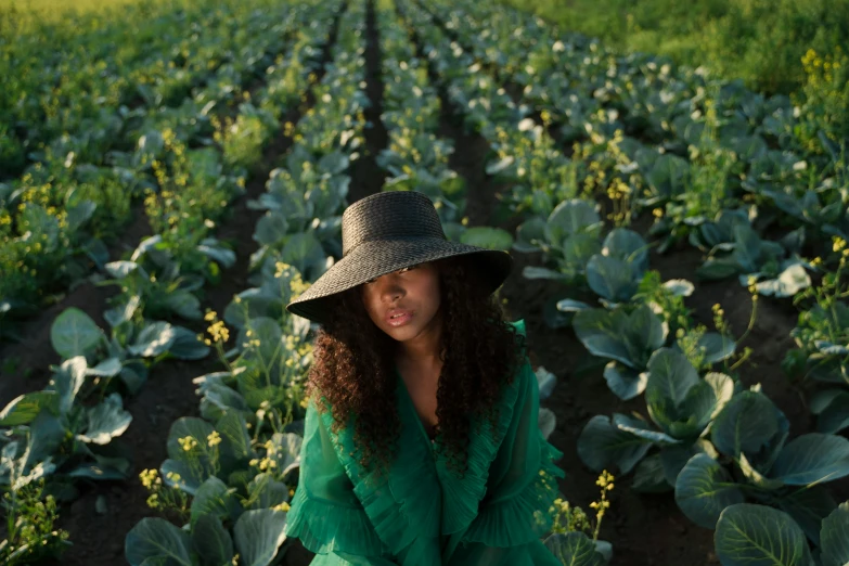 a woman kneeling in a field of cabbage, pexels contest winner, renaissance, with afro, black sun hat, square, sza
