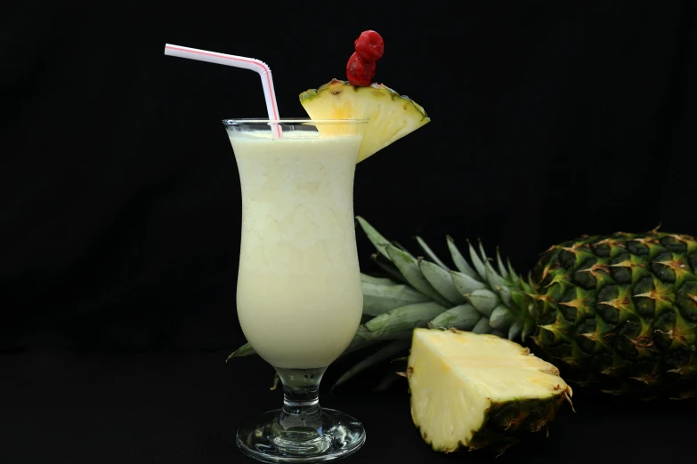 a glass filled with a drink next to a pineapple, milkshake, in front of a black background, jamaican vibe, 6 pack