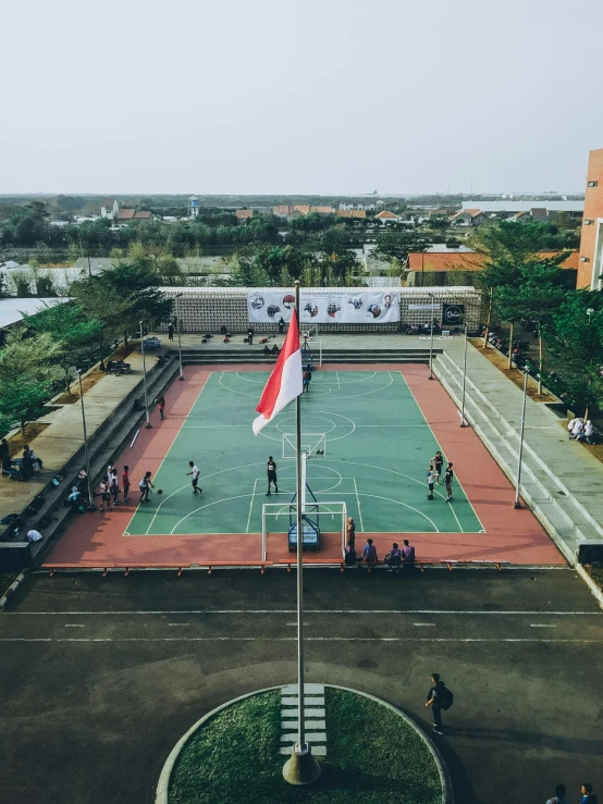 a group of people standing on top of a tennis court, by Bernardino Mei, unsplash contest winner, realism, indonesia, basketball court, school courtyard, helicopter view