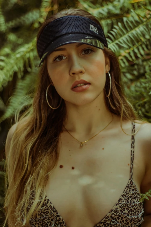 a woman in a bikini top and a hat, an album cover, inspired by Elsa Bleda, trending on pexels, portrait sophie mudd, jewelry, in jungle, wearing baseball cap