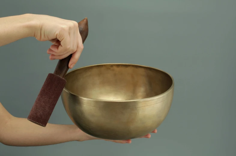 a person holding a singing bowl in their hand, inspired by Gong Xian, large, brass, grey, bowl