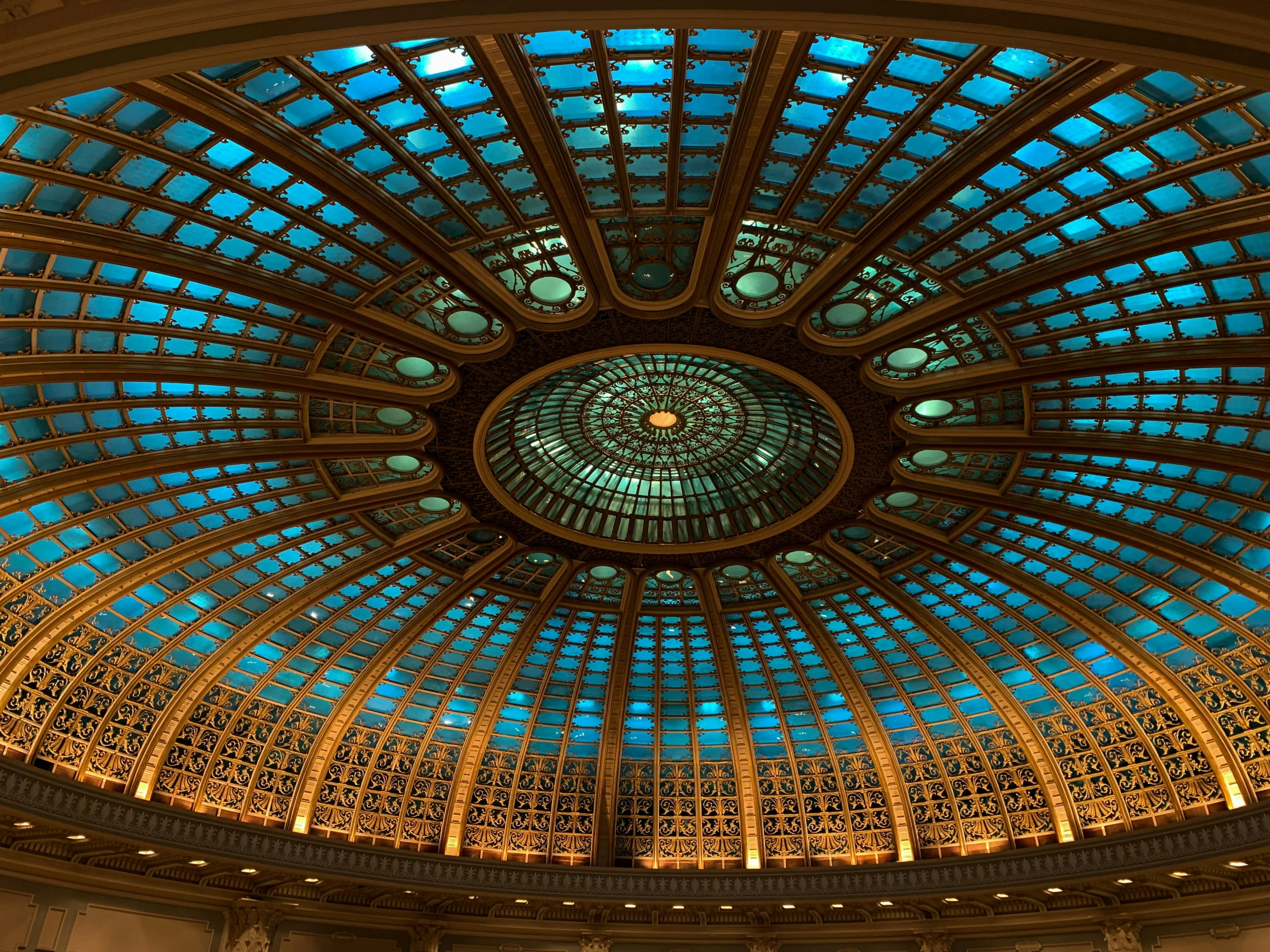 the ceiling of a building with a glass dome, by Meredith Dillman, unsplash contest winner, art nouveau, dimensional cyan gold led light, intricate detailed roof, beautifully lit buildings, masterpiece ”