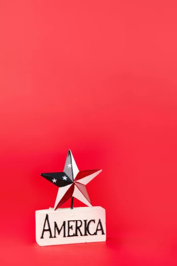a star on top of a sign that says america, by Andrew Stevovich, shutterstock contest winner, simple red background, mini model, high angle view, high quality photo