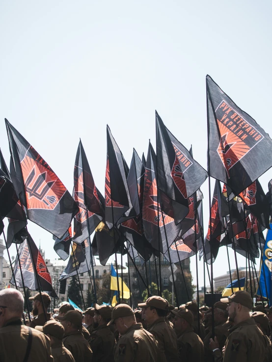 a group of men standing next to each other holding flags, poster art, by Stefan Gierowski, unsplash, socialist realism, ukraine. photography, red and black flags waving, parliament, morning detail