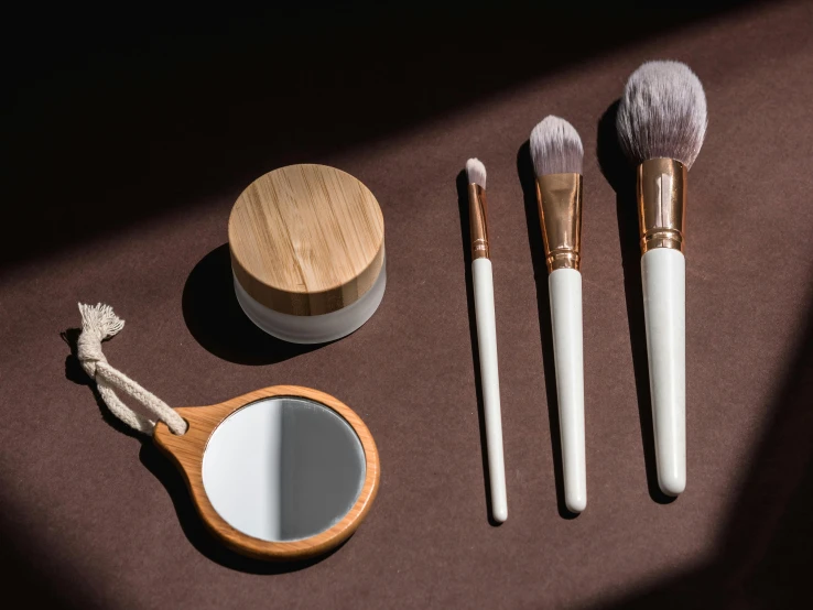 a set of makeup brushes sitting on top of a table, by Julia Pishtar, trending on pexels, plasticien, made of bamboo, brown and white color scheme, mirrors, white facepaint