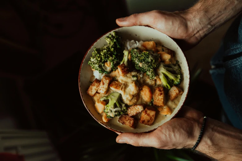 a close up of a person holding a bowl of food, by Julia Pishtar, broccoli, jonny wan, decadent, high quality upload