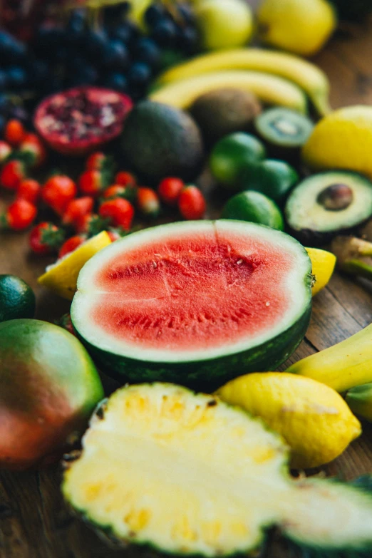 a wooden table topped with lots of different types of fruit, headshot, watermelon, tropical undertones, uncropped