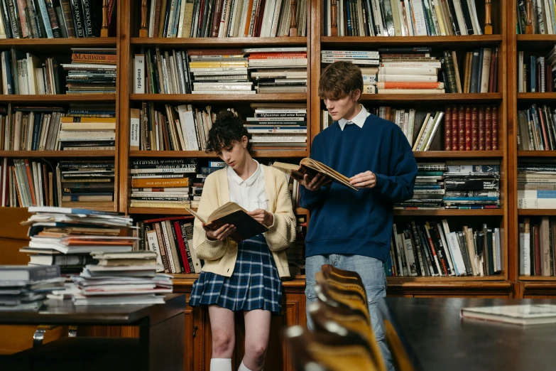 a couple of people standing in front of a bookshelf, by Anna Findlay, pexels contest winner, academic art, school uniform, lachlan bailey, standing in class, reading for a party