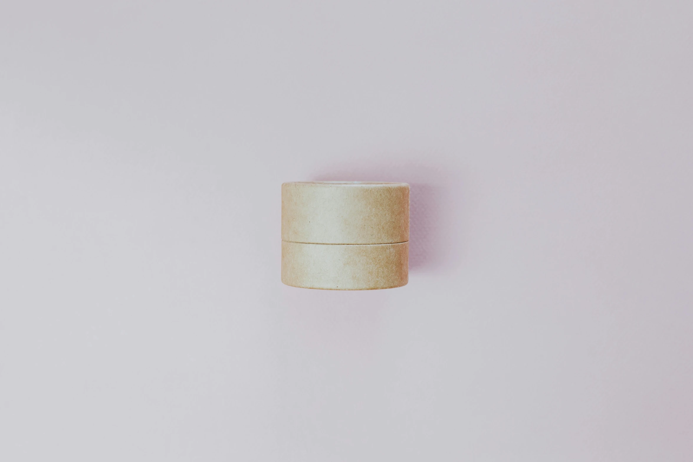 a wooden container sitting on top of a white surface, by Emma Andijewska, unsplash, minimalism, pastel pink skin tone, ring lit, cream paper, ignant
