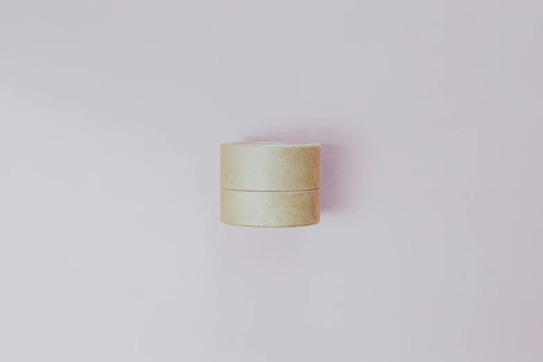 a wooden container sitting on top of a white surface, by Emma Andijewska, unsplash, minimalism, pastel pink skin tone, ring lit, cream paper, ignant