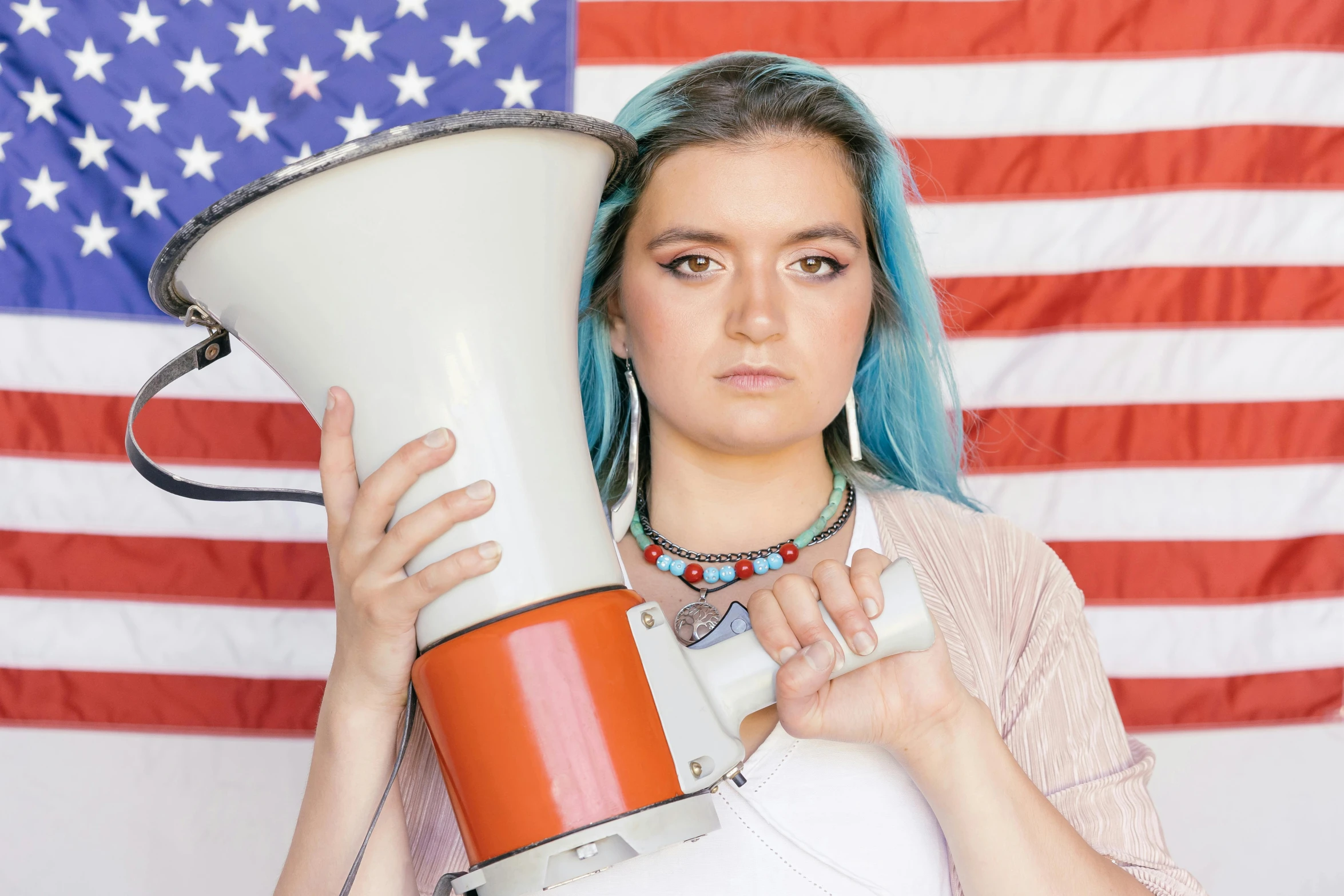 a woman holding a megaphone in front of an american flag, by Winona Nelson, trending on reddit, wearing a native american choker, maisie williams, studio photo, subreddit / r / whale