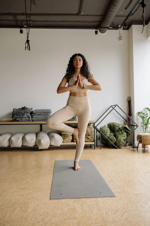 a woman doing a yoga pose in a studio, curated collections, “ full body, beige, video