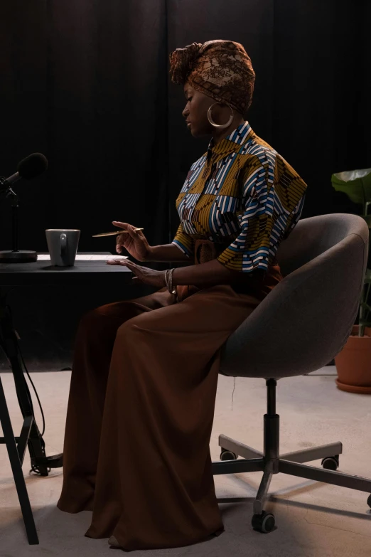 a woman sitting in a chair in front of a microphone, unsplash, afrofuturism, low quality footage, on a desk, full body image, documentary footage