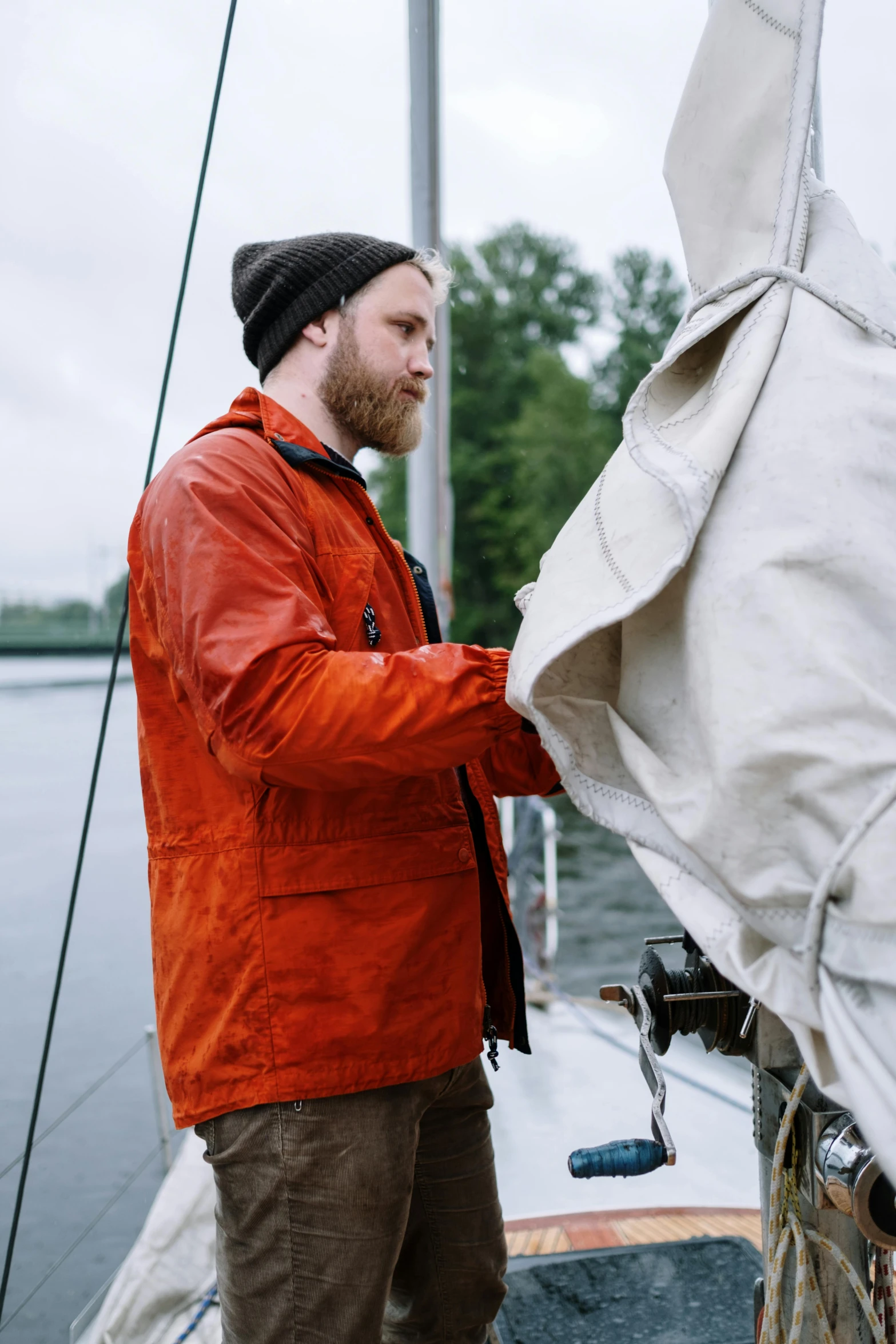 a man that is standing on a boat, orange jacket, craftsmanship, anato finnstark and kelogsloops, outdoor