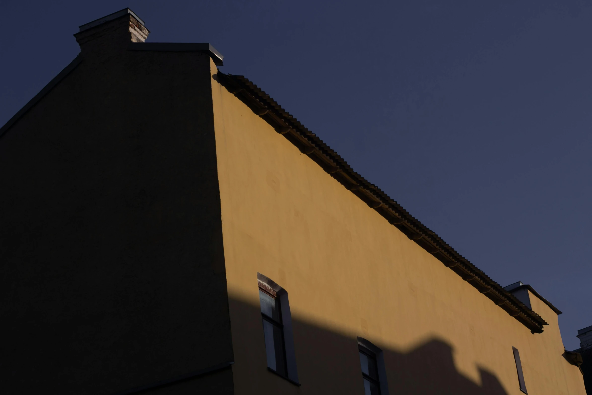 a clock that is on the side of a building, by Tobias Stimmer, postminimalism, sun and shadow, in legnica, golden hour photograph, minimalist photorealist