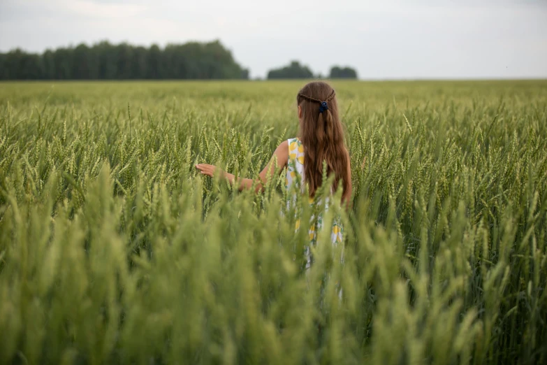 a woman standing in a field of tall grass, a picture, farming, portrait image