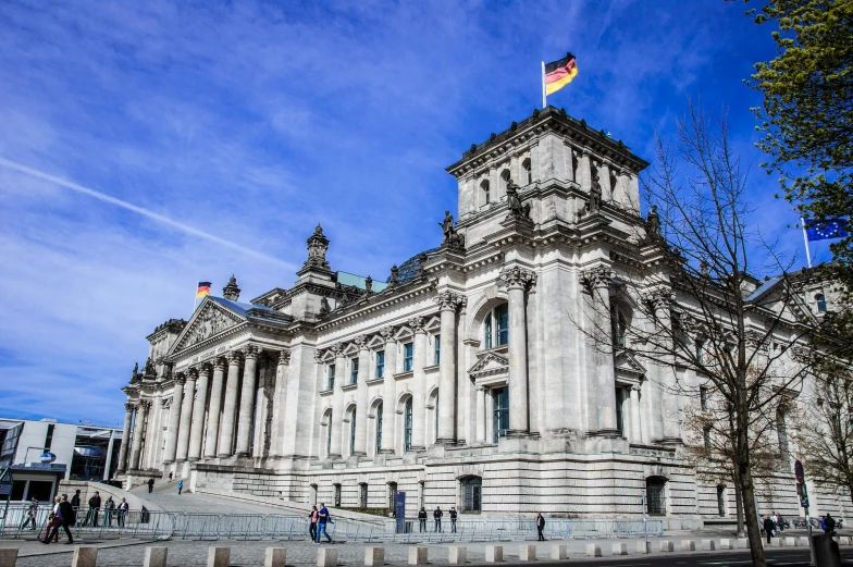 a building with a flag on top of it, inspired by Adolf Dietrich, pexels contest winner, marble statues, german chancellor, 🚿🗝📝