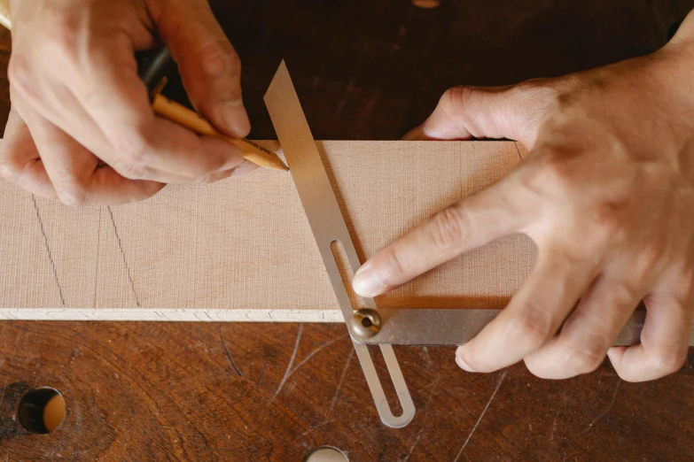 a person cutting a piece of wood with a pair of scissors, an album cover, by Matthias Stom, trending on pexels, arts and crafts movement, square lines, john pawson, small manufacture, brittney lee