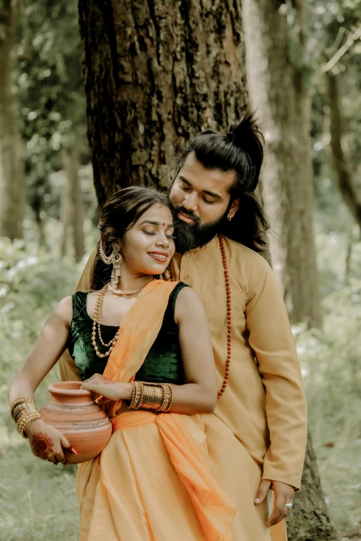 a man and a woman standing next to a tree, by Puru, pexels contest winner, samikshavad, forest themed, woman holding another woman, promo image, hair