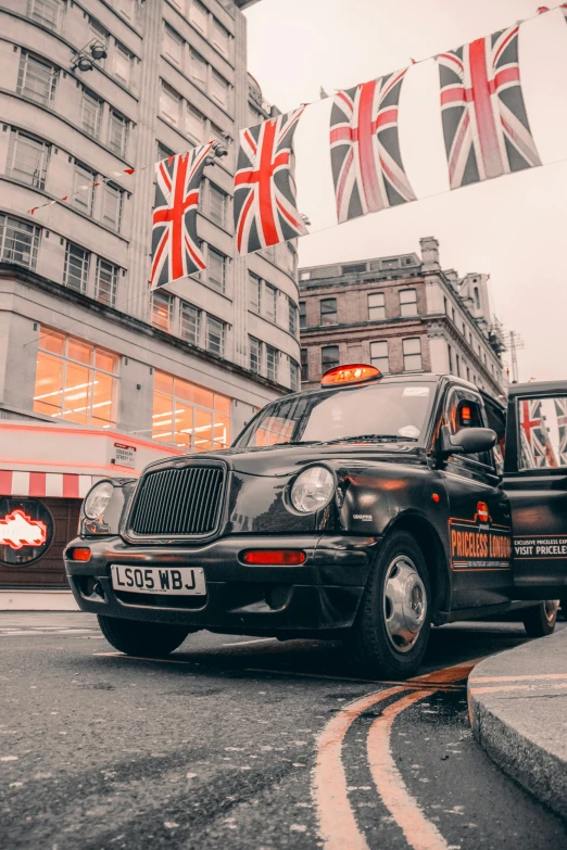 a black cab driving down a street next to tall buildings, pexels contest winner, united kingdom flags, 🚿🗝📝, square, old english