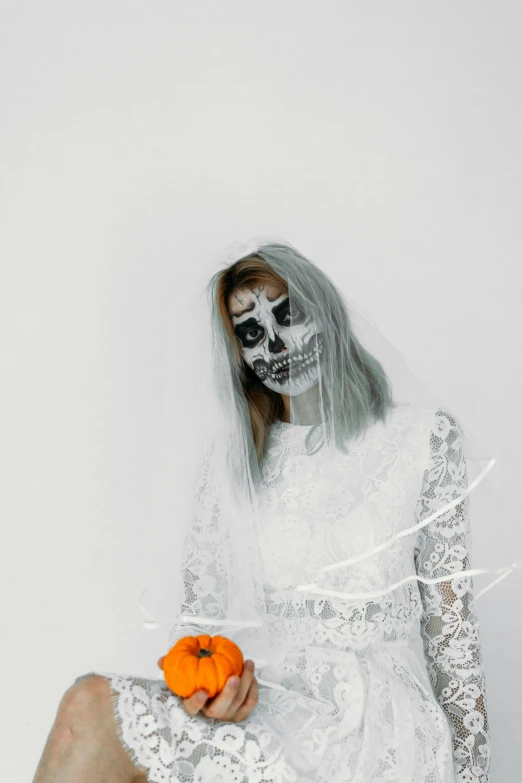 a woman in a white dress holding an orange, a black and white photo, pexels contest winner, lowbrow, skull face paint, girl silver hair, ( ( ( skeleton ) ) ), zombie's