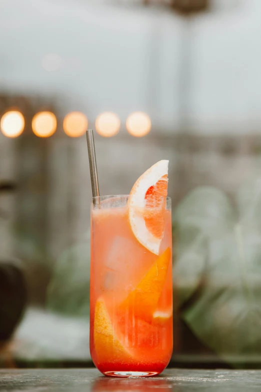 a close up of a drink on a table, light red and orange mood, on a cloudy day, multiple stories, straw