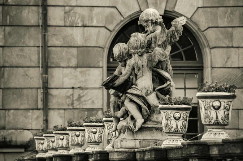 a black and white photo of a statue in front of a building, a statue, by Cherryl Fountain, pexels contest winner, putti, munich, mixed art, delightful surroundings