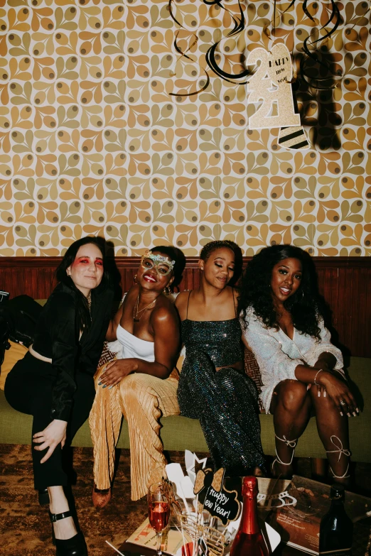 a group of women sitting on top of a couch, an album cover, trending on pexels, sitting at a bar, left eye stripe, high quality photo, ( brown skin )