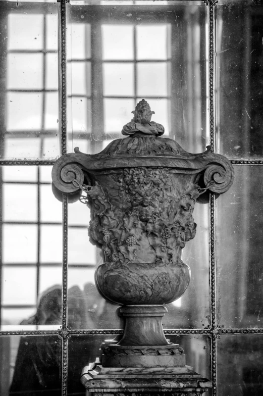 a black and white photo of a vase in front of a window, by Hendrik Gerritsz Pot, palace of the chalice, [ metal ], head details, early 2 0 th century