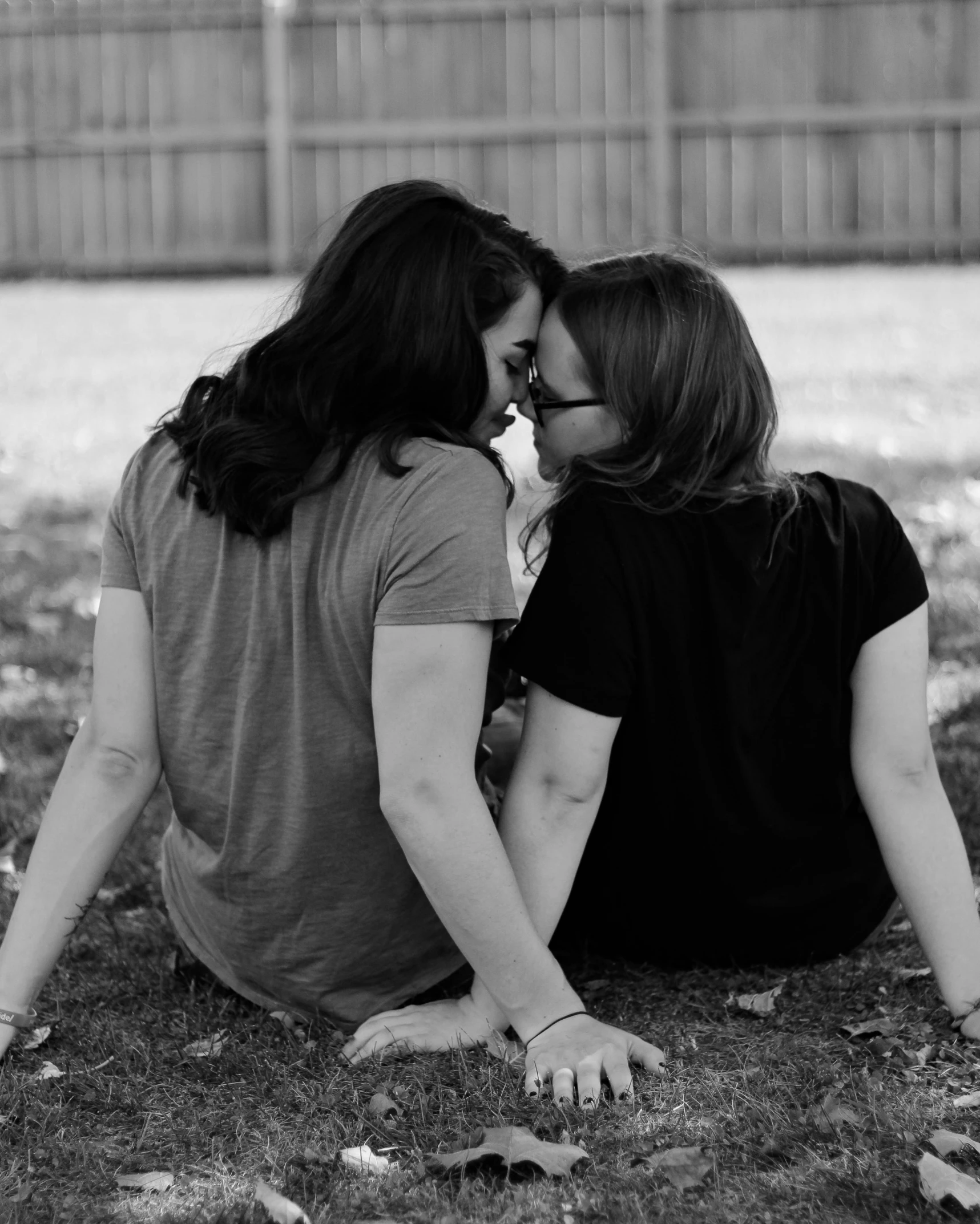 a couple of women sitting on top of a grass covered field, a black and white photo, tachisme, lesbian kiss, 15081959 21121991 01012000 4k, in the yard, kaitlyn michelle siragusa