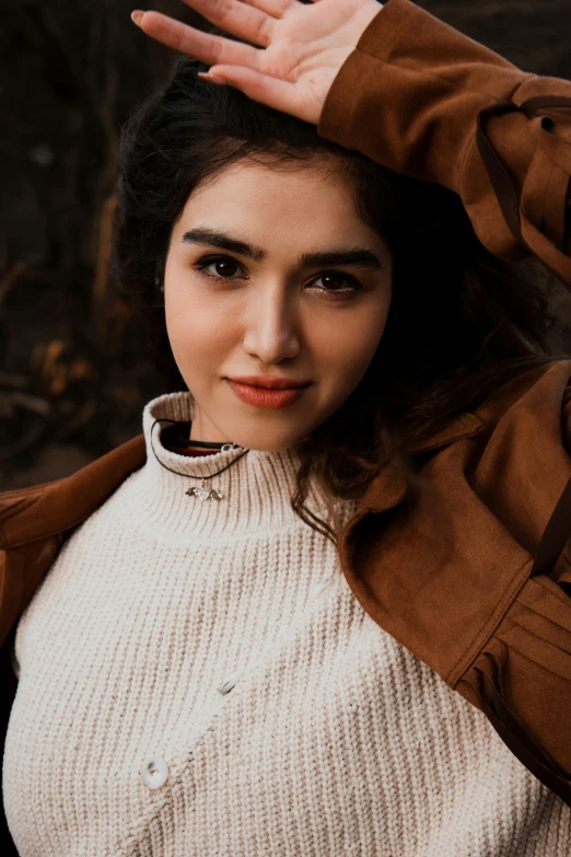 a woman in a brown jacket posing for a picture, by irakli nadar, trending on pexels, maya ali mage, beautiful young himalayan woman, wearing a white sweater, ((portrait))