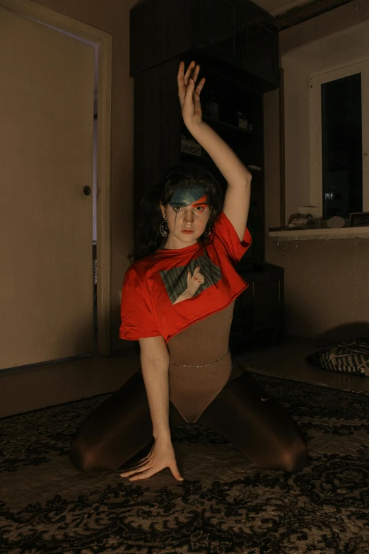 a woman in a red shirt doing a yoga pose, an album cover, inspired by Elsa Bleda, unsplash, renaissance, bodypaint, indoor picture, non binary model, intimidating pose