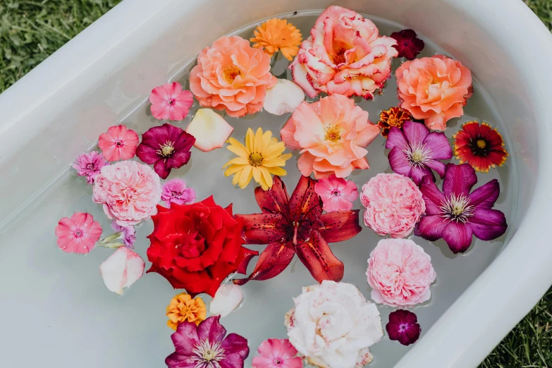 a white bath tub filled with lots of flowers, trending on unsplash, hibiscus flowers, pink orange flowers, carefully crafted, edible flowers