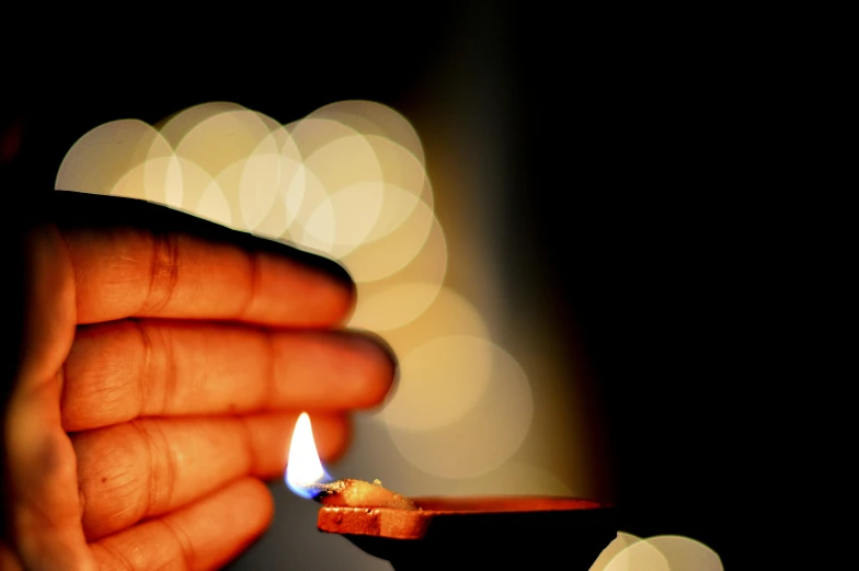 a person holding a lit candle in their hand, light emitting from fingertips, tiny firespitter, mesmerising, animation