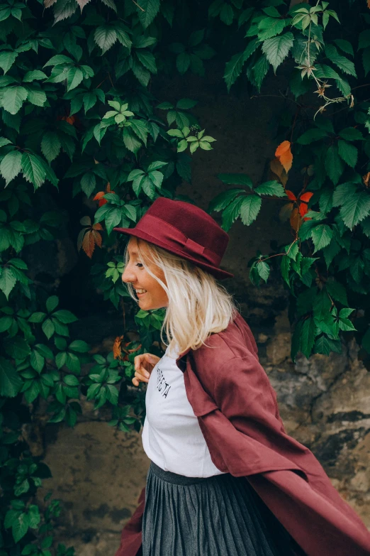 a woman wearing a red hat and a black skirt, pexels contest winner, foliage clothing, maroon, having a good time, profile image